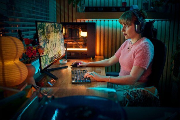 Gamer using keyboard and headset at desk