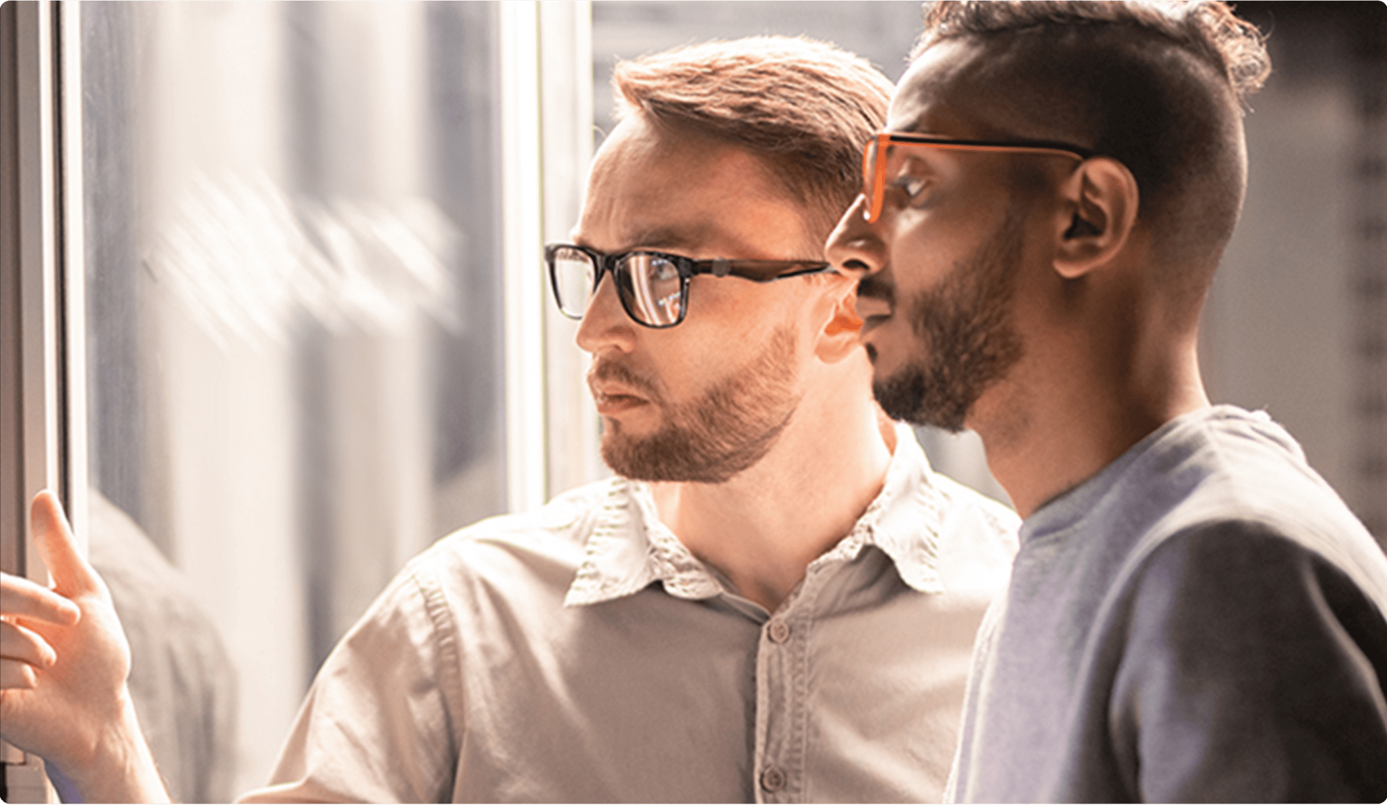 Team-of-young-multi-ethnic-specialists-in-glasses-standing-at-server-and-using-tablet-while-managing-network-server-together-in-data-center-1-min-1